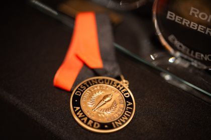 A Distinguished Alumni Award sits on a black table. 